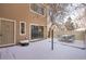 Snow covered backyard with patio furniture and a wood fence at 9573 E Kansas Cir # 57, Denver, CO 80247