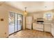 White kitchen cabinets, tile floors and sliding glass doors to backyard at 9573 E Kansas Cir # 57, Denver, CO 80247