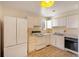 Bright eat-in kitchen with white cabinets and appliances at 9573 E Kansas Cir # 57, Denver, CO 80247