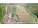 Expansive aerial view of property featuring lush land, residence, outbuildings, and a meandering irrigation canal at 10691 County Road 23, Fort Lupton, CO 80621