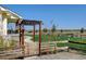 Scenic backyard with a wooden gate leading to the home's covered porch at 10691 County Road 23, Fort Lupton, CO 80621
