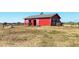 Exterior view of a red barn featuring a horse at 10691 County Road 23, Fort Lupton, CO 80621