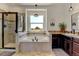 An elegant bathroom features a soaking tub, glass shower, and dark wood cabinets at 10691 County Road 23, Fort Lupton, CO 80621