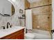 Bathroom with a wood vanity, decorative wallpaper, and combined shower and tub at 10691 County Road 23, Fort Lupton, CO 80621