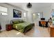 A bright bedroom with hardwood floors, a stylish bed frame, and an office area at 10691 County Road 23, Fort Lupton, CO 80621