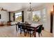 Charming dining area with a chandelier, bright windows, and wood floors adjacent to the living room for easy entertaining at 10691 County Road 23, Fort Lupton, CO 80621