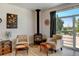 Cozy sitting area featuring a freestanding fireplace, natural light, and access to the outdoor patio at 10691 County Road 23, Fort Lupton, CO 80621