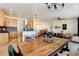 Bright open-concept living and dining area featuring hardwood floors, a ceiling fan, and modern light fixtures at 10691 County Road 23, Fort Lupton, CO 80621