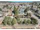A high aerial view of the home and neighborhood with mature trees, and a white fenced yard at 335 Jefferson St, Monument, CO 80132