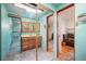 Bright bathroom with a mirrored closet featuring a wooden vanity, mirrored cabinet, skylight, and a glass enclosed shower at 335 Jefferson St, Monument, CO 80132