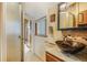 Bathroom featuring a decorative sink, tiled floor, and an enclosed glass shower with a view into an adjacent room at 335 Jefferson St, Monument, CO 80132
