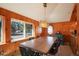 Bright dining room with wood-paneled walls, large windows, and a modern light fixture at 335 Jefferson St, Monument, CO 80132
