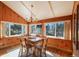 Bright sunroom with wood-paneled walls, vaulted ceiling, and large windows offering abundant natural light at 335 Jefferson St, Monument, CO 80132