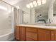 Bright bathroom featuring a double sink vanity, a tub with a shower, and a large mirror at 3525 E 139Th Pl, Thornton, CO 80602