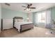 Cozy bedroom with mint green walls, a ceiling fan, carpet flooring, and a large window at 3525 E 139Th Pl, Thornton, CO 80602