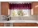 Bright kitchen showcasing a stainless-steel sink, white countertops, and cabinets, complemented by a scenic window view at 3525 E 139Th Pl, Thornton, CO 80602