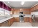 Well-lit kitchen featuring modern appliances, ample counter space, and stylish cabinets with functional layout at 3525 E 139Th Pl, Thornton, CO 80602