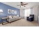 Comfortable living room with a modern ceiling fan, a stylish sofa, and a blue accent wall at 3525 E 139Th Pl, Thornton, CO 80602