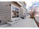 Back patio with a sliding glass door to the home, concrete slabs, and partial fencing at 3525 E 139Th Pl, Thornton, CO 80602