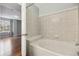 Bright bathroom features a soaking tub with decorative tile surround and a view to a spacious bedroom at 14399 E Grand Dr # 150, Aurora, CO 80015