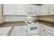Traditional kitchen featuring white cabinetry, and a range with a built-in microwave at 14399 E Grand Dr # 150, Aurora, CO 80015