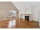 Well-lit living room with a fireplace, hardwood floors, and a window overlooking the yard at 14399 E Grand Dr # 150, Aurora, CO 80015