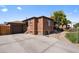 Brick home with attached garage and well-maintained landscaping at 4747 Shoshone St, Denver, CO 80211