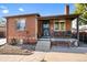 Brick ranch home with a landscaped lawn and a covered porch at 4747 Shoshone St, Denver, CO 80211