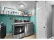 Basement laundry room with washer, dryer, and storage shelves at 4747 Shoshone St, Denver, CO 80211