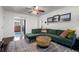 Living area with green sectional sofa and view of kitchen at 4747 Shoshone St, Denver, CO 80211