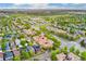 Expansive aerial view showcasing townhomes amidst verdant trees, a commercial area, and distant mountains at 10044 Martin Luther King Blvd, Denver, CO 80238