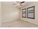 A bedroom with neutral paint, carpet flooring, two windows and ceiling fan at 10044 Martin Luther King Blvd, Denver, CO 80238