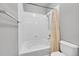 Bright bathroom with tub shower featuring white tile and a shower curtain at 15700 E Jamison Dr # 6-201, Englewood, CO 80112