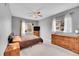 Carpeted bedroom featuring a ceiling fan, dresser, and TV with natural lighting at 15700 E Jamison Dr # 6-201, Englewood, CO 80112