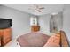 Carpeted bedroom featuring a ceiling fan, dresser, TV, and natural lighting at 15700 E Jamison Dr # 6-201, Englewood, CO 80112