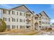 Condo exterior showing the private balcony, gray siding, and brick entry stairs at 15700 E Jamison Dr # 6-201, Englewood, CO 80112