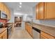 A kitchen with tile floors, stainless steel appliances and wooden cabinets that opens to the dining area at 15700 E Jamison Dr # 6-201, Englewood, CO 80112