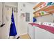 Laundry room with washer, dryer, wooden shelves and an apron hanging on a hook at 15700 E Jamison Dr # 6-201, Englewood, CO 80112