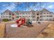 Community playground with slides in front of condo buildings featuring outdoor stairs and balconies at 15700 E Jamison Dr # 6-201, Englewood, CO 80112