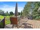 Outdoor deck area featuring a table, chairs, a grill, and expansive views of the landscaped backyard at 7583 S Xanthia Ct, Centennial, CO 80112