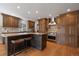 Gourmet kitchen featuring wood cabinets, an island with bar seating, and stainless steel appliances at 7583 S Xanthia Ct, Centennial, CO 80112