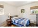 Cozy bedroom featuring a blue striped quilt, a side table with a lamp, and natural light at 1275 Berea Dr, Boulder, CO 80305