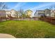 Large, grassy backyard with wooden fence separating the property from neighboring houses at 2574 Cove Creek Ct, Highlands Ranch, CO 80129