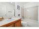 Clean bathroom featuring tiled shower-tub combo, white fixtures, and a wooden vanity at 2574 Cove Creek Ct, Highlands Ranch, CO 80129