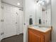 Clean bathroom with single sink vanity, white walls, and adjacent hallway at 2574 Cove Creek Ct, Highlands Ranch, CO 80129