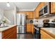 Well-lit kitchen features stainless steel appliances, wood cabinets, and a dark hardwood floor at 2574 Cove Creek Ct, Highlands Ranch, CO 80129