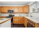 Kitchen with stainless appliances, wood cabinets, and a sink overlooking a window at 2574 Cove Creek Ct, Highlands Ranch, CO 80129