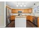 Spacious kitchen offers a center island, stainless appliances, hardwood floors and a tiled backsplash at 2574 Cove Creek Ct, Highlands Ranch, CO 80129