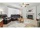Cozy living room with a fireplace, a ceiling fan, and leather furniture set on carpet at 2574 Cove Creek Ct, Highlands Ranch, CO 80129