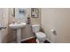 Clean and well-maintained powder room featuring a pedestal sink and toilet at 9636 W 71St Pl, Arvada, CO 80004